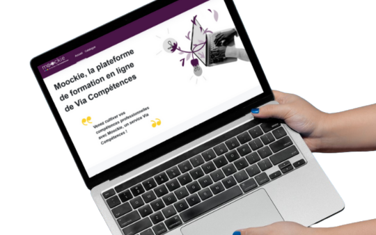 Ordinateur tendu à bout de bras qui présente la page d'accueil du site moodkie.fr